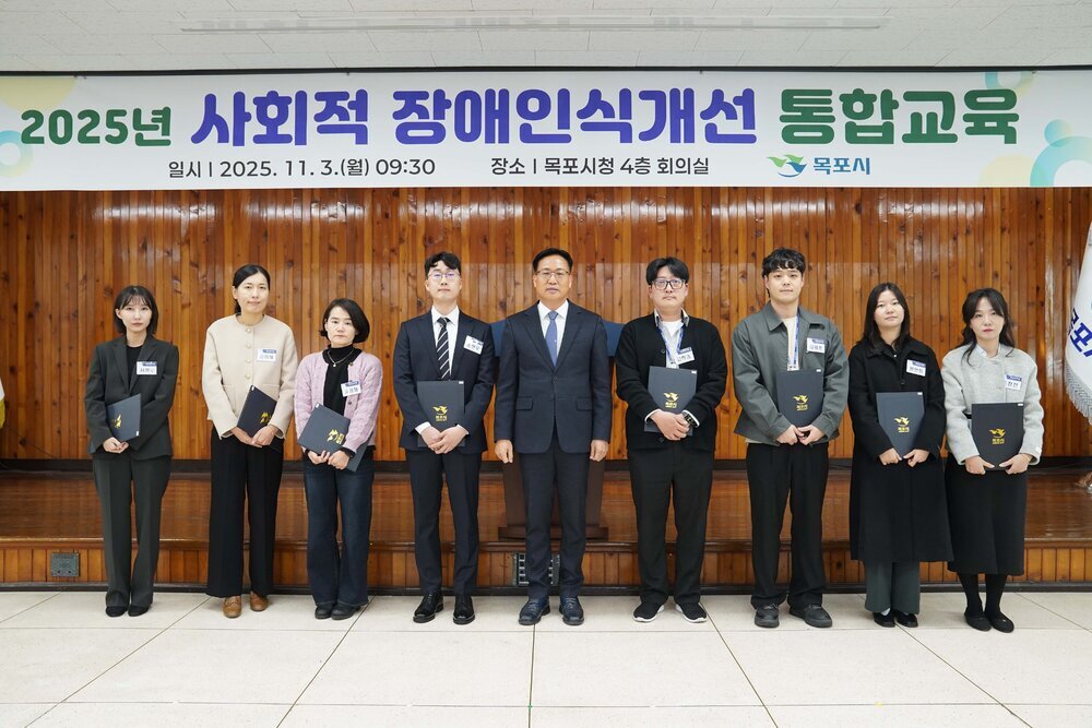 시상식 단체 기념사진. '2025년 사회적 장애인식개선 통합교육 | 일시 2025. 11. 3.(월) 09:30 | 장소 목포시청 4층 회의실 | 목포시' 현수막 아래에서 시상자와 수상자 10명이 상장을 들고 나란히 서 있음.