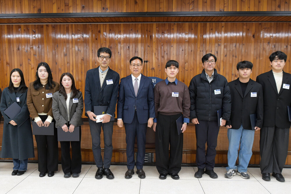 3월 정례조회 행사에서 정장을 입고 안경을 쓴 남성이 수상자들과 함께 기념촬영을 하고 있으며, 왼쪽부터 황상현, 이름표가 가려진 여성, 박루비, 차소정, 윤성근, 윤종원, 정구성, 강재현, 이건, 박지은이 상장을 들고 일렬로 서 있다.